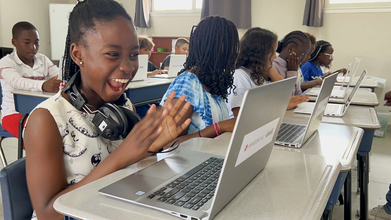 아프리카 세네갈 현지 학교 학생들이 신세계아이앤씨가 기부한 노트북과 함께 교실에서 기념 사진을 촬영하는 모습