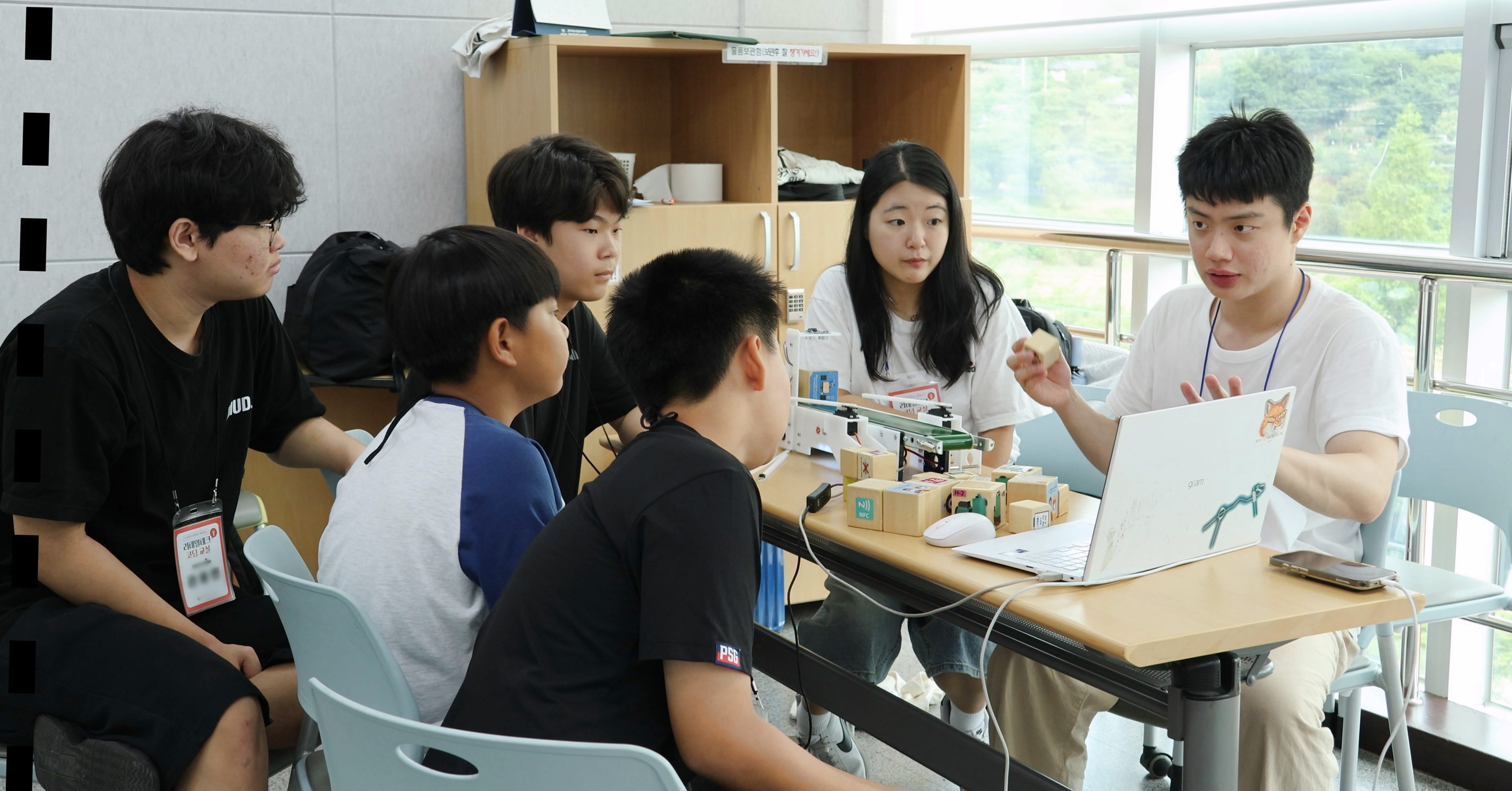 신세계아이앤씨 청소년대상 소프트웨어 교육기부 활동 현장.  한 학교 학생들이 모여 멘토로부터 설명을 듣고 있는 모습
